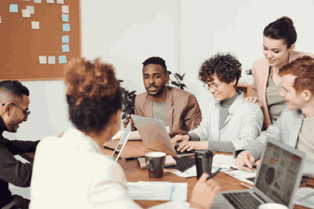 A diverse team of workers in a meeting smiling